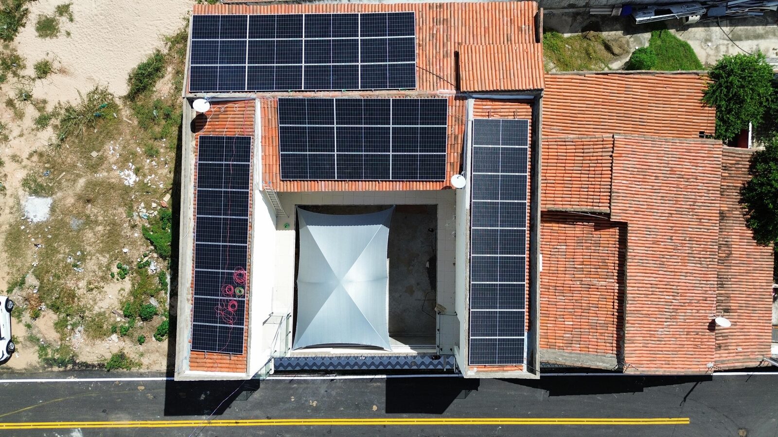 Vista aérea de painéis solares da WF Solar em telhado residencial, Alto do Rodrigues/RN